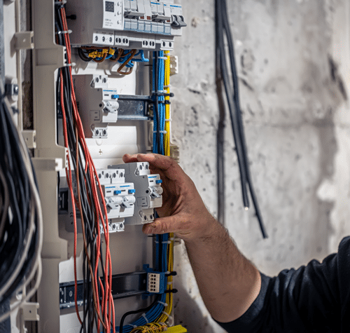 Electrician works inside a breaker panel