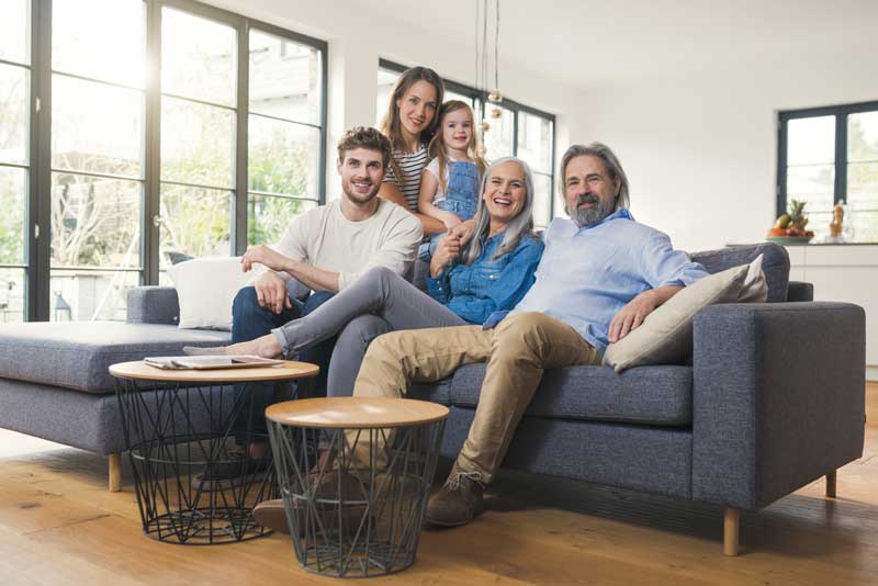 Happy Family Smiling while sitting on their couch in their home