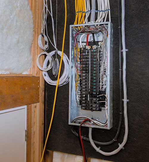 Open electrical panel with exposed yellow and white wiring